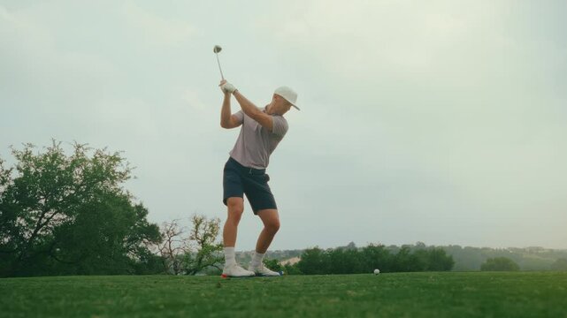 A male golfer drives the ball off the tee box as the sun flares through the frame. Filmed from a low upward angle during golden hour, the clip captures motion, atmosphere, and dramatic natural light.