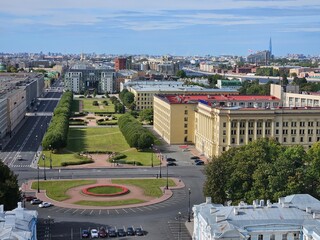 City street with a large round park in the middle Rastrelli Square. There are many buildings in a...