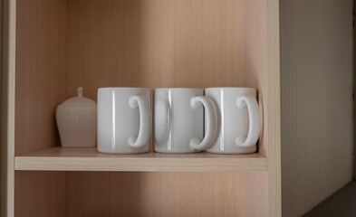 White ceramic mugs on a shelf