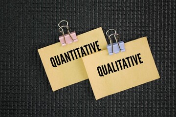 Paper with the words quantitative and qualitative.  Qualitative data focuses on descriptions and...