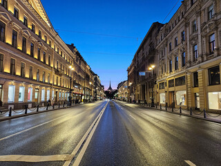 Street with a building on the right side Nevsky Prospect. The street is wet and the sky is blue in...