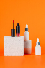 Mockup of black blank thin tube - mascara, lip gloss, gel, eyeliner, oil, etc. Cosmetic package with stylish props on orange background.
