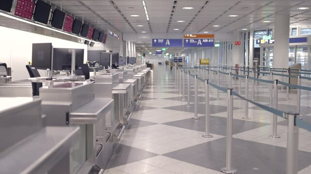Take a moment to explore the serene and tranquil interior of an empty airport checkin area, which beautifully showcases modern checkin counters and clear signage designed specifically for travelers