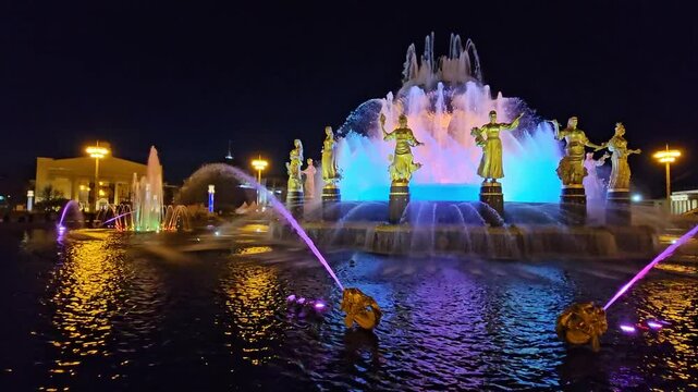 MOSCOW - SEP 29, 2023: Fountain Friendship of the Peoples of the USSR with a statue of a woman in the middle. The water is purple in VDNH