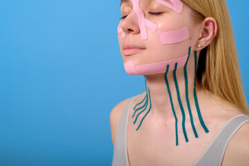 woman practicing beauty taping technique with kinesiology tapes on face and neck. skincare routine...