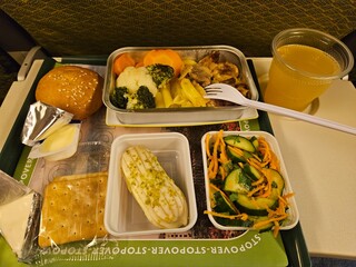 Tray of food with a fork and a cup of juice. The tray has a sign that says Stopover Superstore in...