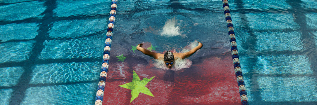 Mid-race swimmer captured above China's national flag in water. Visual metaphor of international rivalry, effort, and unity. Concept of national sports identity