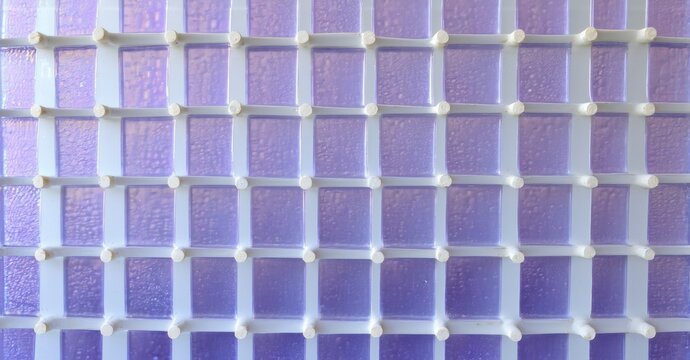 Plastic grid holding purple squares. Texture appears frosted, creating interesting light effects. Simple, repetitive pattern dominates image.