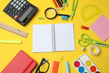 Children school supplies flat lay on yellow background with copy space