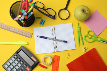 Children school supplies flat lay on yellow background with copy space