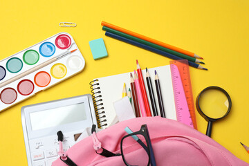 Children school supplies flat lay on yellow background with copy space