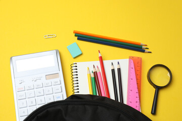 Children school supplies flat lay on yellow background with copy space