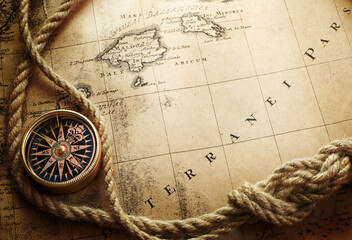Magnetic old compass and. rope on world map. Travel, geography, history, navigation, tourism and exploration concept background. Retro compass on geography map.