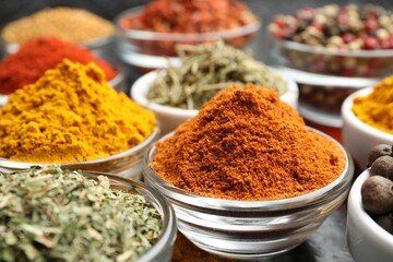 Different aromatic spices in bowls on table, closeup