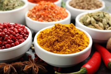 Different aromatic spices in bowls on table, closeup