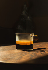 Espresso coffee in a glass cup on a dark background in vertical.