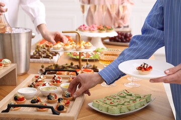 People with different appetizers at buffet, closeup