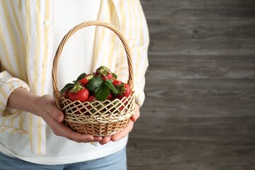 Woman with delicious ripe strawberries indoors, closeup. Space for text