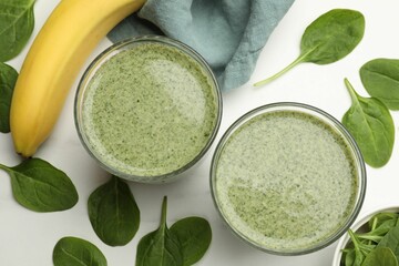 Tasty spinach smoothie and ingredients on white table, flat lay