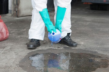 Hazmat Worker Collecting Spilled Liquid in Blue Container