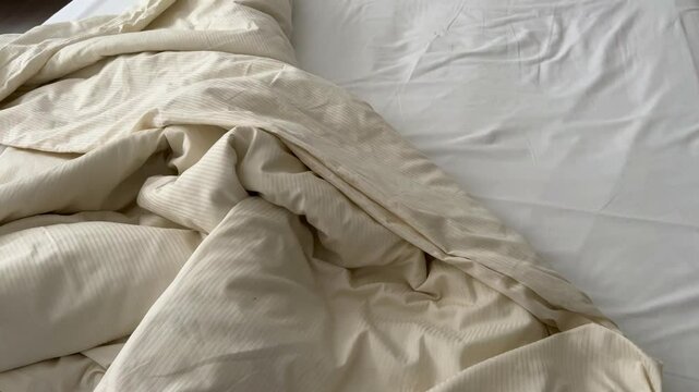 messy bed with white bedding sets in a bedroom of a house or hotel room. home interior concept 4k video with untidy bedroom.