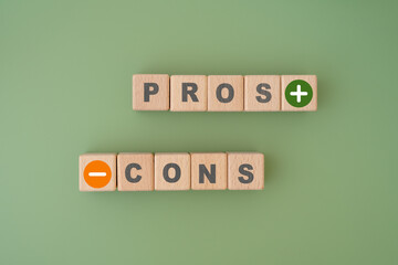 Pros and Cons word on wooden cube blocks with green color background