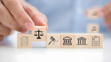 Naklejka premium Hand placing wooden block with scales of justice symbol next to legal icons