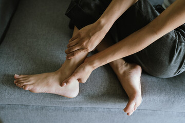 An adult sits holding his foot in pain, expressing discomfort, stress on his foot, and the need for...