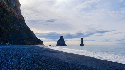 Discover the stunning landscapes of Reynisfjara Beach beneath a cloudy Icelandic sky