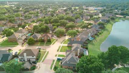 Fototapeta premium Waterfront upscale suburban neighborhood near Rheudasil Park in Flower Mound, suburbs Dallas Texas, lakeside two-story single-family homes with large green backyards, swimming pools, lush trees