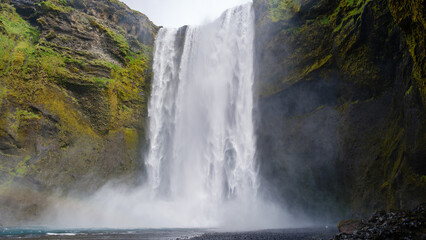 Majestic Skogafoss waterfall cascading down cliffs in Icelands lush landscape