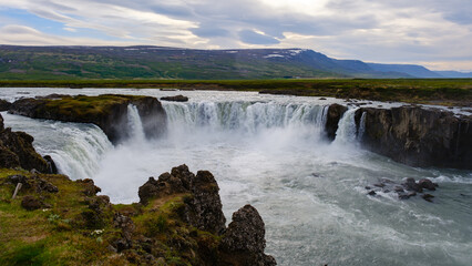 Spectacular waterfall cascading over rocky cliffs in the breathtaking landscapes of Iceland