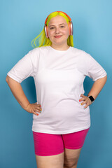 Confident Young Woman In White T-Shirt And Pink Shorts On Blue Background
