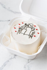 Small trendy bento cake decorated with silhouette of happy family together drawing. Happy International Father's Day cake in a gift box