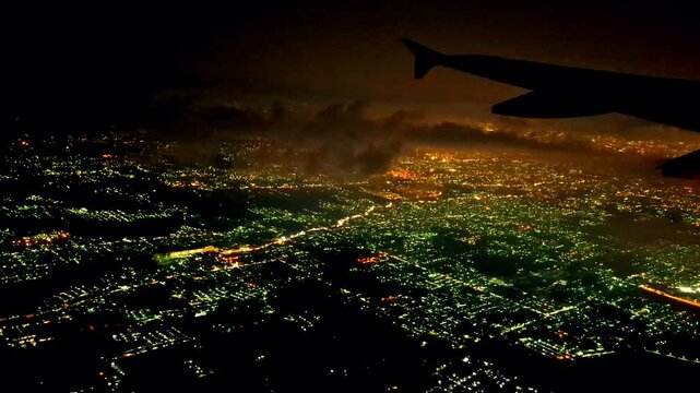 Night flight in Indonesia from Soekarno Hatta airport, Jakarta to Kualanamu, Medan. Dark mode with light points on buildings, street lights, transportation and various lights from the ground. 