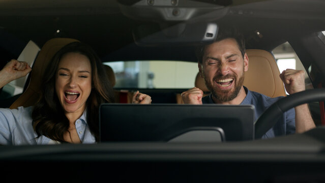 Happy couple celebrate buying new car sitting inside salon achieve gesture Caucasian family boyfriend girlfriend wife husband male female woman man girl guy rejoice buy auto automobile rent test drive - Powered by Adobe