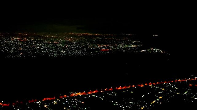 Night flight in Indonesia from Soekarno Hatta airport, Jakarta to Kualanamu, Medan. Dark mode with light points on buildings, street lights, transportation and various lights from the ground. 