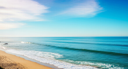 Azure seascape and sandy beach present tranquil coastal scenery under a serene sky during daytime.