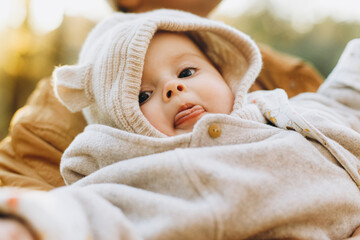 Portrait of happy cute baby boy in fathers hands in soft evening light in autumn woods. Fatherhood....