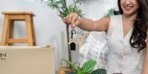 Moving Home. Woman holding house key while unpacking in new apartment.