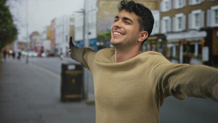 Man arms stretch wide in outdoor air behind hispanic young smiling scene with city street male...