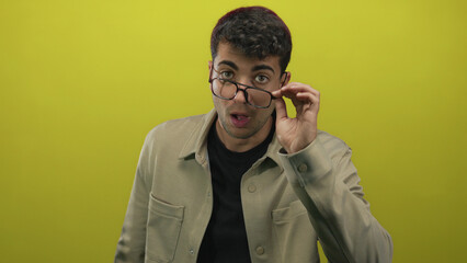 Man with glasses adjusts them on background, spectacles highlight young hispanic features with...