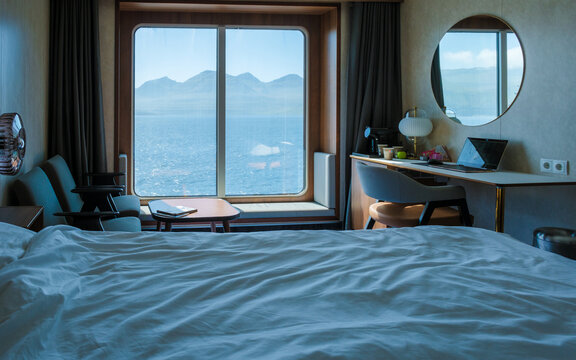 Scenic coastal view from a cruise boat room in the Faroe Islands showcasing serene mountains