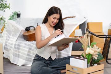 Moving Home. Woman organizing her new space while jotting down notes.