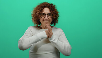 Middle-aged hispanic woman with curly brunette hair gesturing a fight pose with fist in palm...