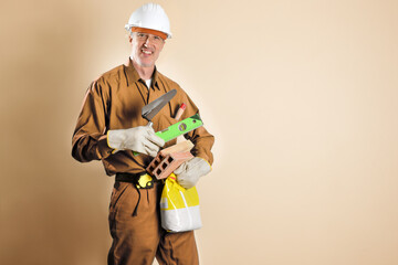 Smiling bricklayer holding tools and building materials brown isolated background