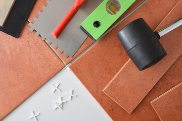 Laying tiles with spacers with tools on top