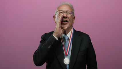 Senior man in business suit with medal over isolated pink wall passionately shouting with...