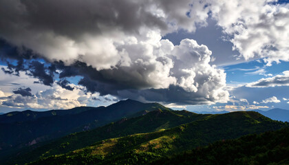 Fototapeta premium Majestic Mountain Landscape Under Dramatic Cloudy Sky at Sunset