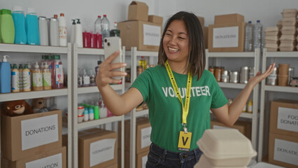 Woman smiling during a video call in a donation center surrounded by organized shelves of hygiene...